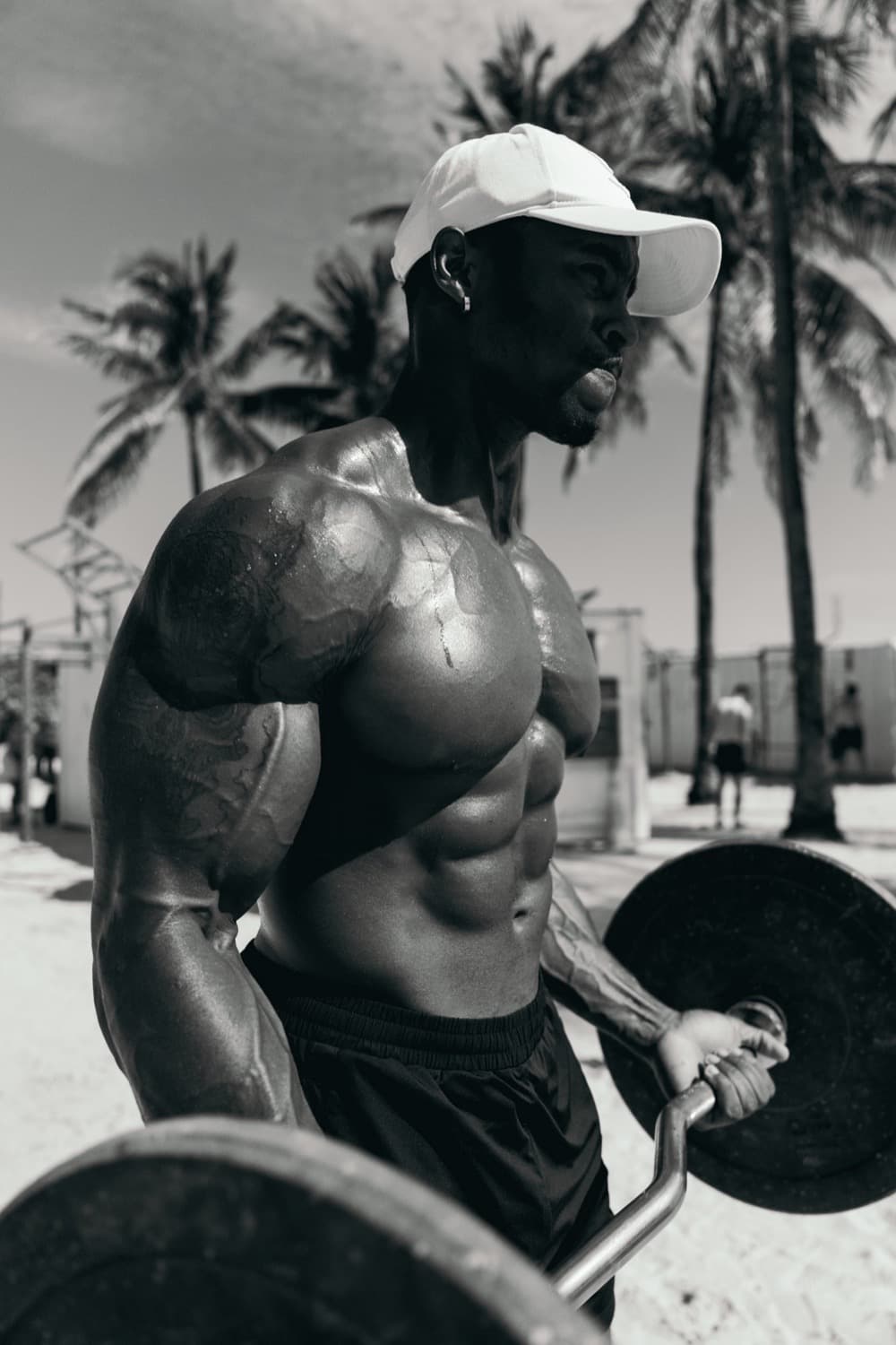 Chris holding a curl bar at an outdoor gym.