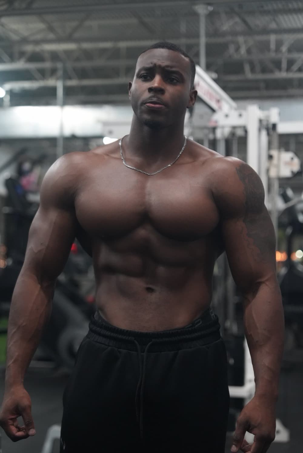 Chris standing in the gym, looking toward the camera.